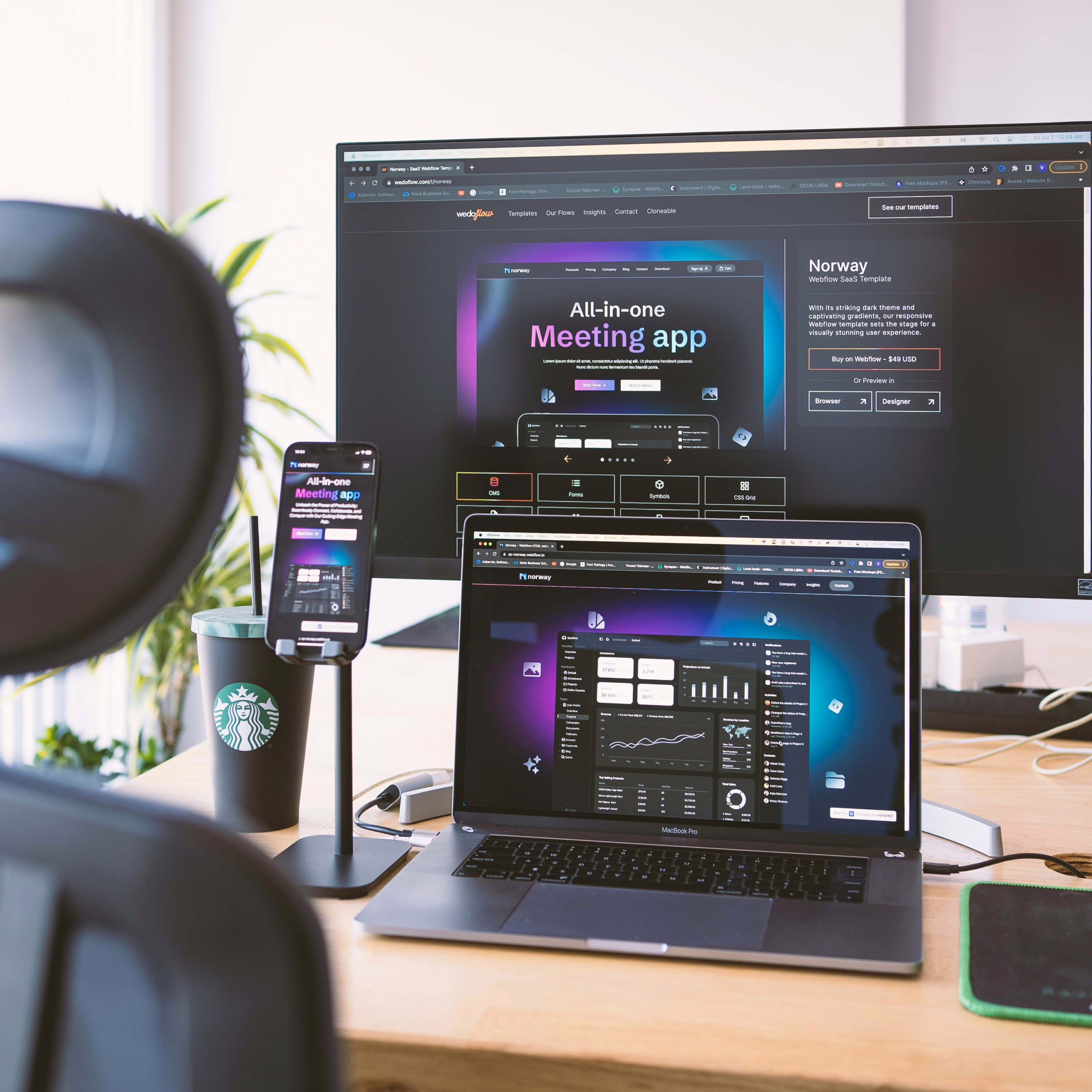 A grey laptop with a PC monitor on a wooden desk