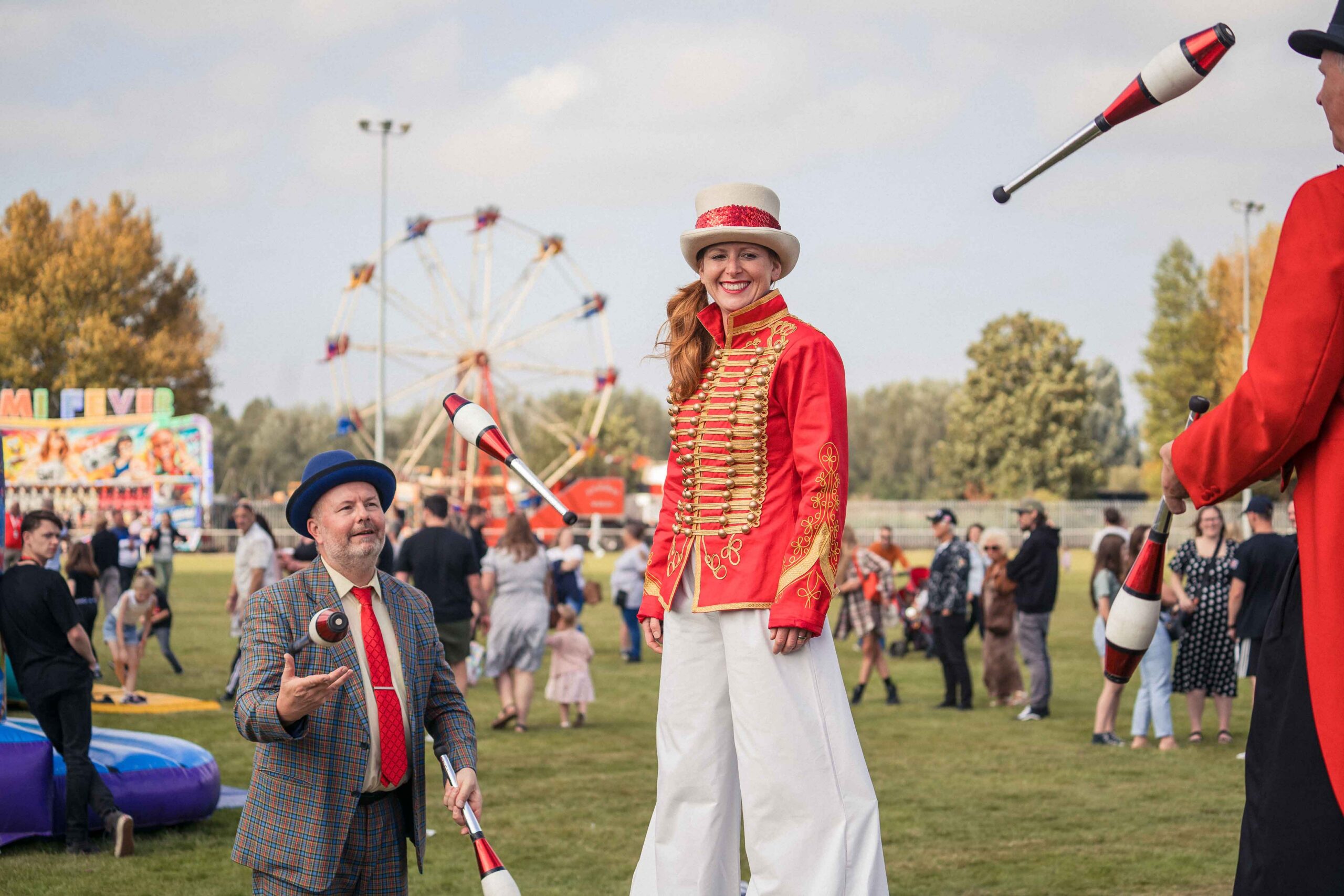 Collins Aerospace Family Fun Day, attendees walking past fairground rides